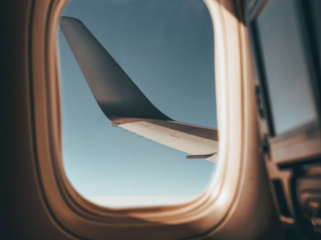 جناح طائرة من نافذتها، مثال لوكالة سفر يجيب بوتها عن الباقات